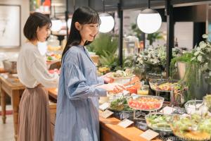 京都的住宿－東京烏丸-五條京王帕里雅酒店，两名妇女在杂货店准备食物