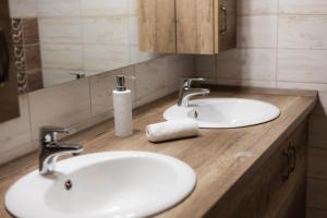 a bathroom with two white sinks and a mirror at Maya Panzio in Szeged