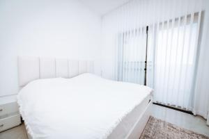 カスリンにあるאירוח בגולןの白いベッドルーム(ベッド1台、窓付)
