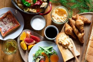 a wooden table topped with plates of food and bread at Keio Prelia Hotel Kyoto Karasuma-Gojo in Kyoto