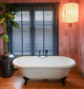 a bath tub in a bathroom with a window at Villa la Vida in Tilburg