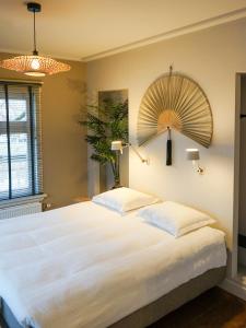 a bedroom with a large white bed with two pillows at Villa la Vida in Tilburg