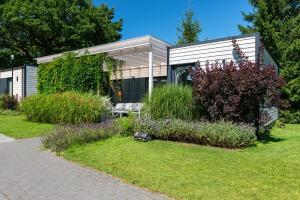 a house with a bench and flowers in the yard at M2 Resort Wellness & Spa in Ostrowo