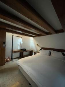a bedroom with a large white bed and a table at Abode Bombay in Mumbai