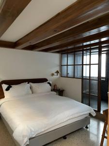 a bedroom with a large white bed and a window at Abode Bombay in Mumbai