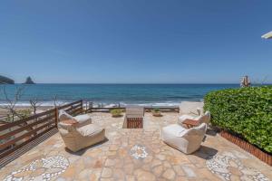 a patio with chairs and the ocean in the background at Glorious Sunset & Sea View Studio Mariastella 5 in Agios Gordios