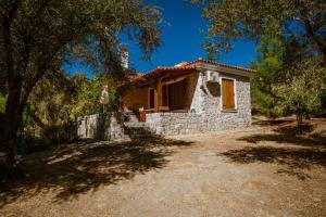 a small stone house in the middle of a yard at Traditional Stone House in Seafront Olive Grove A in Alyfantá