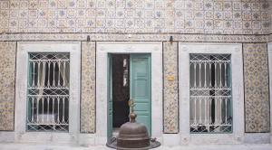 a building with two windows and a green door at Dar Ben Gacem Kahia in Tunis