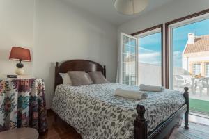 1 dormitorio con cama y ventana grande en Best Houses 21 - Surf House Perfect Location, en Baleal