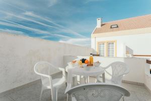 - Balcón con mesa blanca y sillas en Best Houses 21 - Surf House Perfect Location, en Baleal