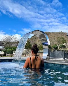 a woman in a swimming pool with a fountain at The Swan Hotel and Spa in Newby Bridge