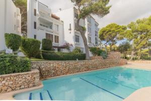 una piscina di fronte a un edificio di Apartamento Ferrera Park 407 a Cala Ferrera