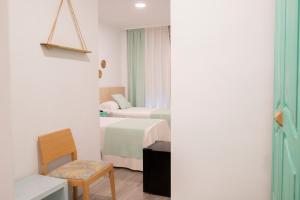 um quarto de hotel com duas camas e uma cadeira em El Globo em Valência