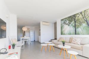 un soggiorno con un divano, un tavolo e delle sedie di Apartamento Ferrera Park 407 a Cala Ferrera