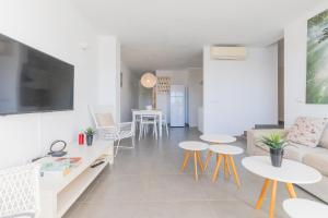 un soggiorno con divano e tavoli di Apartamento Ferrera Park 407 a Cala Ferrera