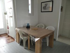 アルカションにあるMaison Arcachon, 3 pièces, 4 personnes - FR-1-319-35のキッチン(木製テーブル、白い椅子付)