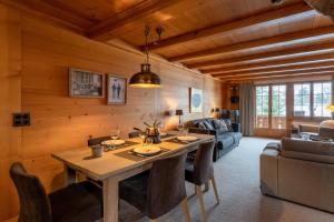 Cozy Place in Gstaad center في غشتاد: غرفة طعام مع طاولة وأريكة