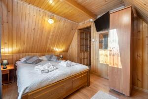 um quarto com uma cama num chalé de madeira em Villa Kucówka em Brzegi