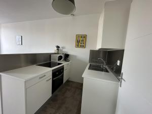 eine kleine weiße Küche mit einer Spüle und einem Herd in der Unterkunft Studio Port-Vendres, 1 pièce, 2 personnes - FR-1-309-110 in Port-Vendres