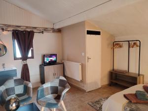 sala de estar con 2 sillas y TV en Õ 2040 Chambre Marmotte en Saint-Véran