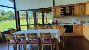 a kitchen with a table and chairs and a large window at Gostnici Holiday Home in Razlog