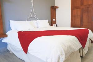 a bed with a red and white blanket on it at Delmás Hotel Emblemático in Haría