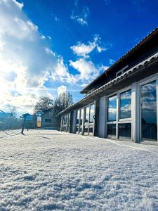 un edificio con nieve en el suelo delante de él en Hotel Bergstätter Hof en Immenstadt im Allgäu