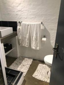 Un baño con inodoro, lavabo y toallas. en 317 Maboneng On Craft, en Johannesburgo