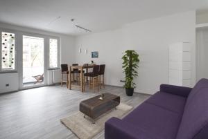 ein Wohnzimmer mit einem lila Sofa und einem Tisch in der Unterkunft Apartment Hannover Top Citylage in Hannover