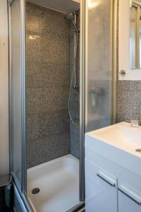 a shower with a glass door next to a sink at Ferienwohnung Wrixumer Marsch in Wrixum