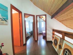 a hallway with two doors and a room with a bed at Estada inesquecível 01 Guarapari in Guarapari