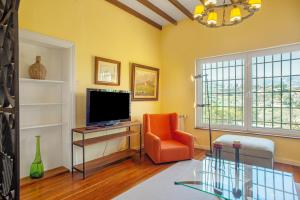 ein Wohnzimmer mit einem orangenen Stuhl und einem TV in der Unterkunft La Veguetilla in Vega de San Mateo