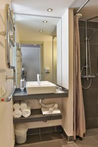 a bathroom with a sink and a mirror at Le Galet Hotel & Spa in Saint-Philibert