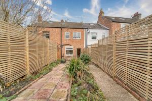 a garden with wooden fences in front of a house at Guest Homes - Loughborough Road House in Leicester