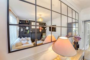 Guest Homes - Loughborough Road House في ليستر: غرفة معيشة مع مرآة كبيرة على الحائط