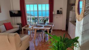 a living room with a dining room table with a view of the ocean at Casa Conchi-Finca Medina in Alojera