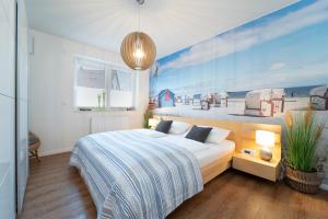 ein Schlafzimmer mit einem Bett und einem Gemälde eines Strandes in der Unterkunft Brenkenhagener Weg 8 -10 Calimera in Grömitz