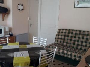 Cette chambre comprend une table, des chaises et un lit. dans l'établissement Maison La Faute-sur-Mer, 2 pièces, 3 personnes - FR-1-476-144, à La Faute-sur-Mer