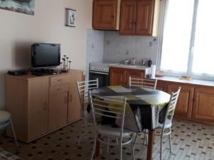 een keuken met een tafel en stoelen en een televisie bij Maison La Faute-sur-Mer, 2 pièces, 3 personnes - FR-1-476-144 in La Faute-sur-Mer