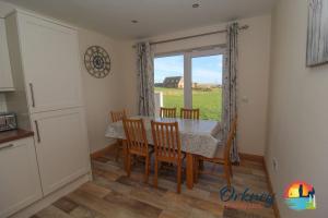 a kitchen and dining room with a table and chairs at Quoylee, Stromness, Orkney - OR00309F in Orkney