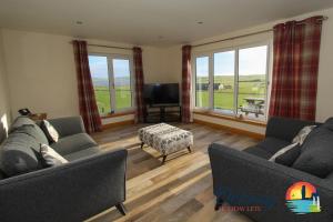 a living room with two couches and a flat screen tv at Quoylee, Stromness, Orkney - OR00309F in Orkney