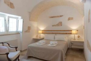 オストゥーニにあるLa Piazzetta dei Trulliのベッドルーム1室(ベッド1台、タオル2枚付)