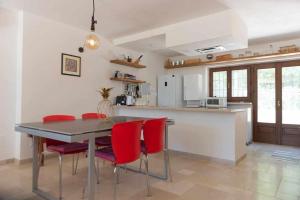 オストゥーニにあるLa Piazzetta dei Trulliのキッチン(ダイニングテーブル、赤い椅子付)