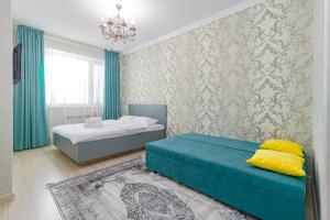 um quarto com 2 camas e um lustre em ЖК 7Я em Astana