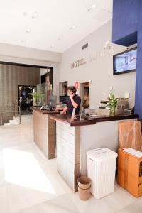 a man is standing at a hotel counter at Hotel Subur in Sitges