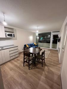 cocina y sala de estar con mesa y sillas en Deptos acogedores con inmejorable ubicación, en Valdivia