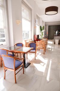 un comedor con mesas de madera y sillas azules en Hotel Subur, en Sitges