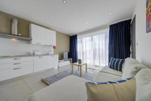 uma sala de estar com um sofá e uma cozinha em CityVista - Gzira Apartments and Penthouse by ShortletsMalta em Il-Gżira