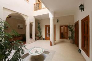 una sala de estar con una gran habitación con una mesa en Riad BB Marrakech, en Marrakech