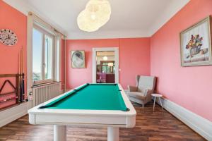 een pooltafel in een kamer met roze muren bij Villa Bellevue Rüschlikon in Rüschlikon